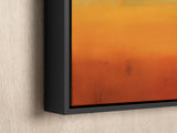 an orange and yellow painting hanging on a wall