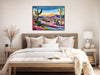 a painting of a desert scene hangs above a bed