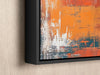 an orange and blue painting hanging on a wall