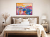 a painting hangs above a bed in a bedroom